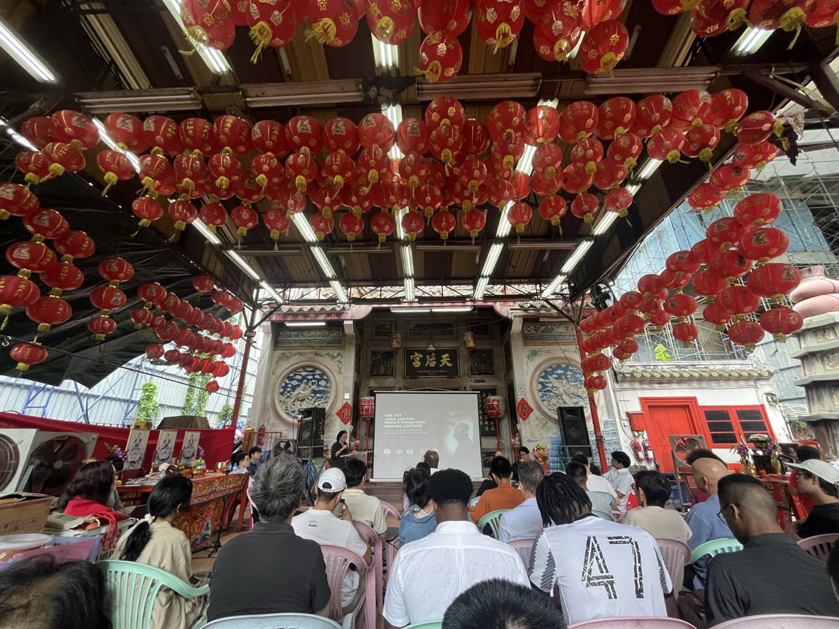 An audience seated under rows of red lanterns at Sam Yan Commons, facing a screen reading The 1st Jane Jacobs Pansit Torsuwan Annual Lecture.