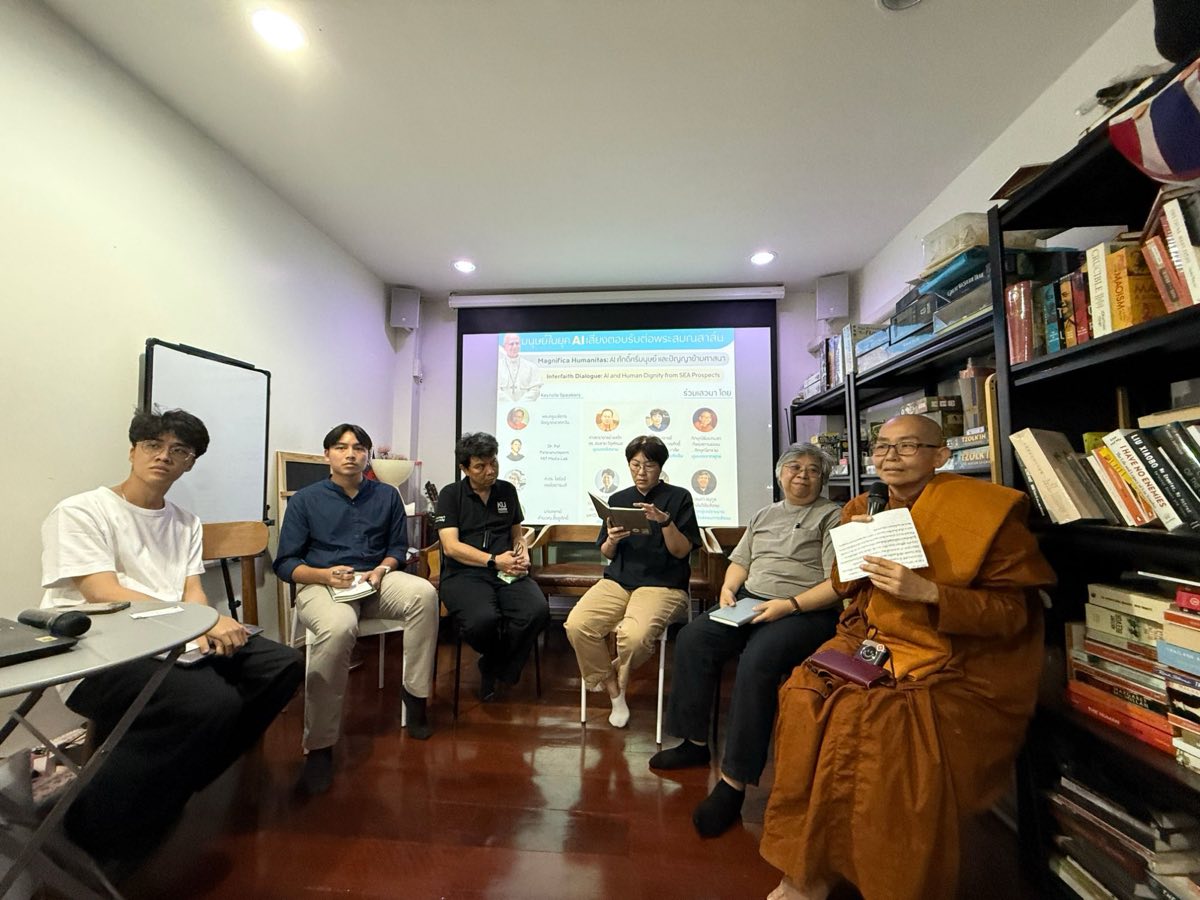 Six panellists seated in a row at Sam Yan Commons, one reading from a notebook, another holding a microphone and a sheet of notes, with the event's title slide projected behind them.